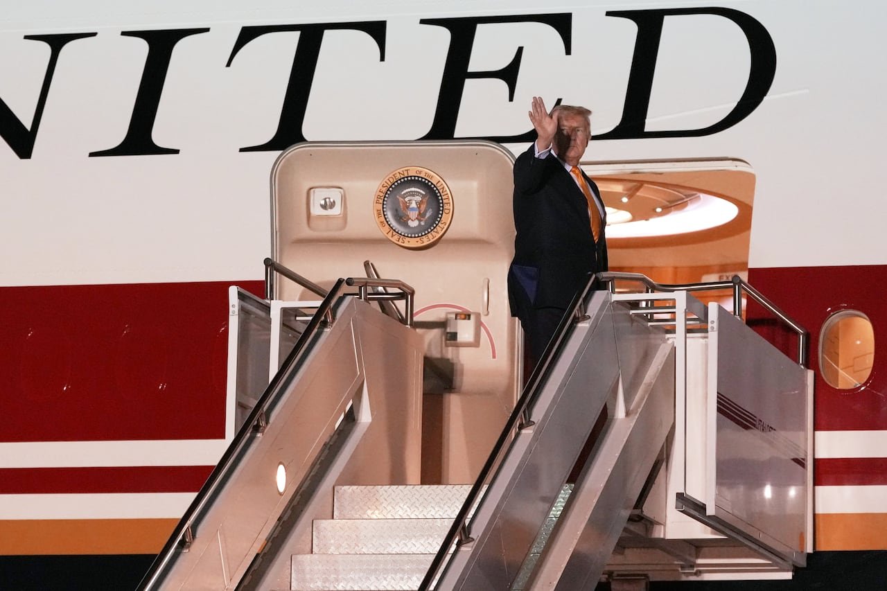 default-1002 A man waves from the top of the staircase leading to an airplane.